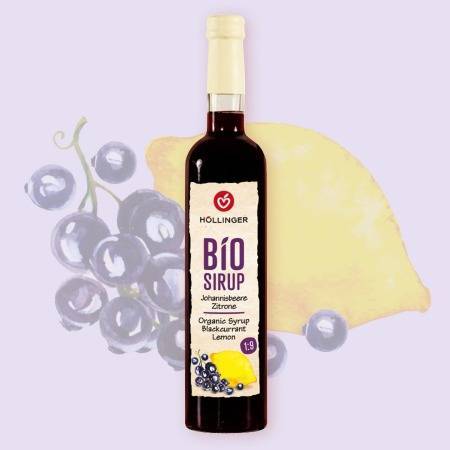 Höllinger Bio Sirup Johannisbeere Zitrone in Glasflasche vor einem Hintergrund mit Johannisbeeren und einer Zitrone