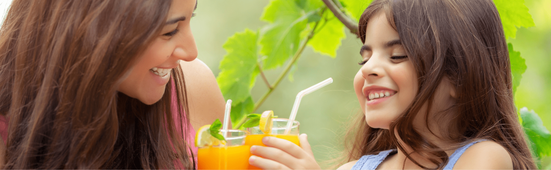 Höllinger Fruchtsaft - Jetzt online bei Höllinger bestellen! Mutter und Tochter mit Fruchtsaft vor einer Weinrebe.