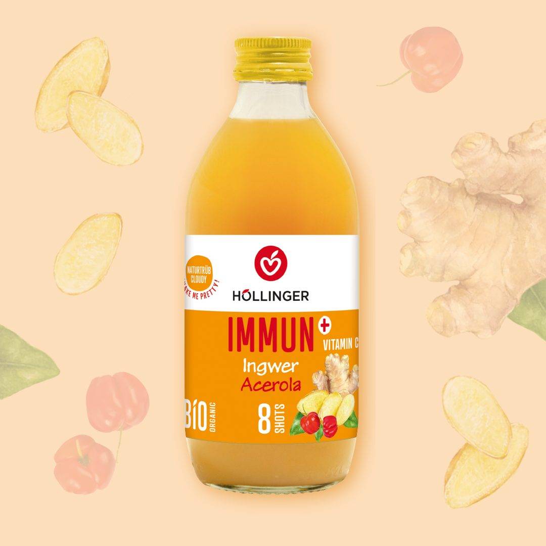 Höllinger's Immun+ Ingwer Acerola Bio-Shot in der 330ml Glasflasche vor einem Hintergrund mit Ingwerknollen und Acerolabeeren.