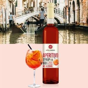 Höllinger Aperitivo Sirupflasche und Glas Aperitivo Spritz vor Gondeln in Venedig.